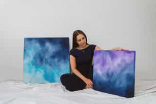 Martina insieme a due delle sue opere astratte